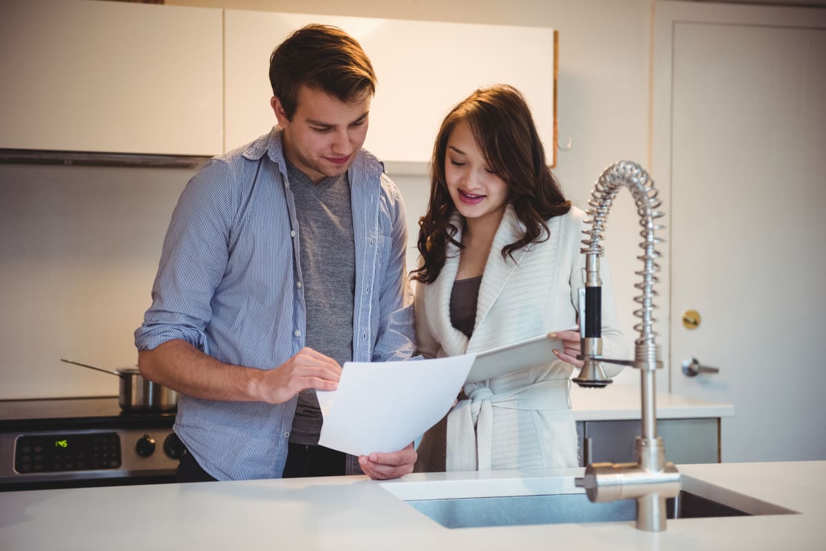 Two homeowners reviewing their water-usage report together on a tablet